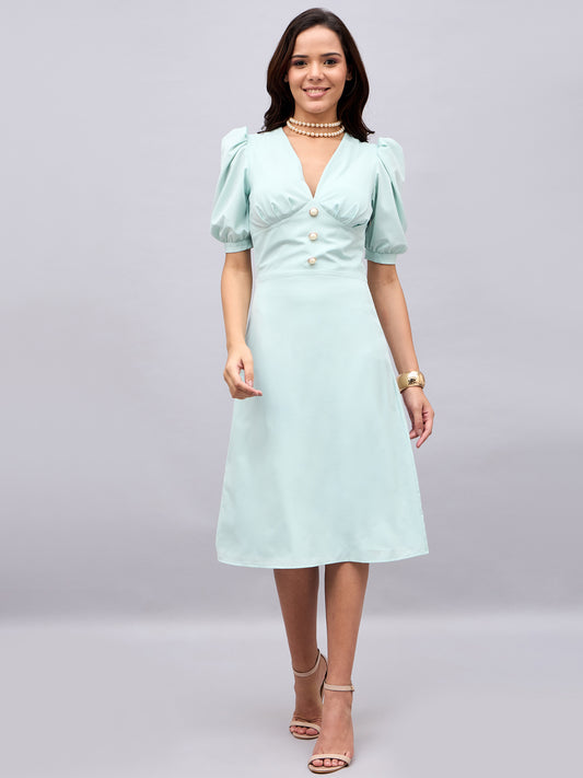 Model in sage green puff sleeve dress holding champagne – NUWAH Grace edit
