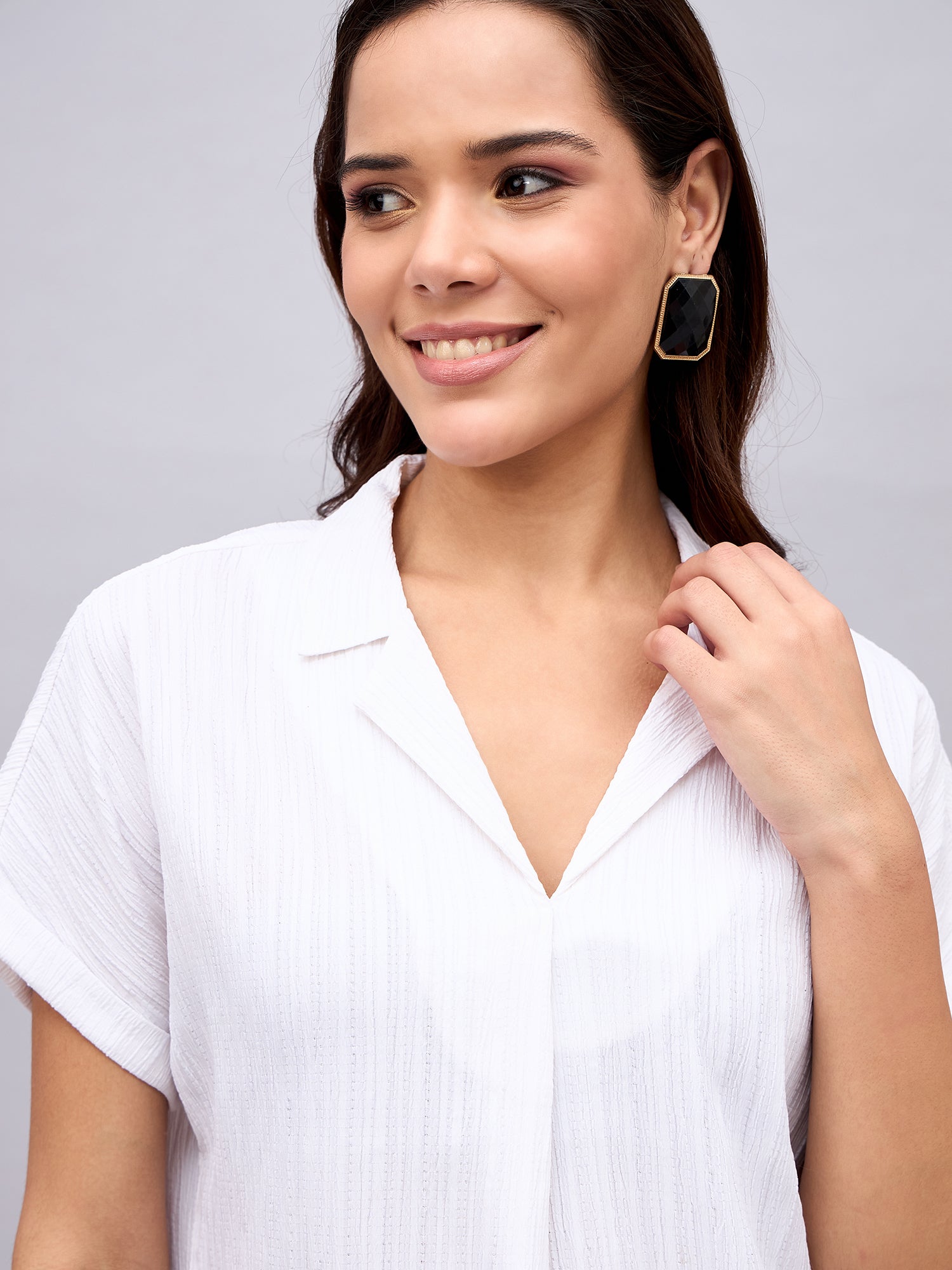 White NUWAH Cuban top paired with black pants – walking lifestyle shot
