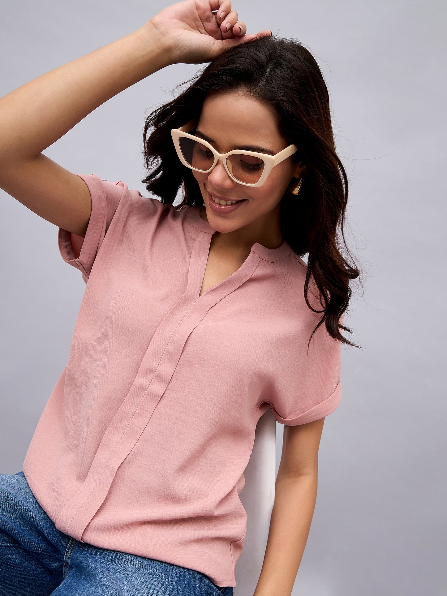 Seated pose in NUWAH pink top – relaxed outfit styling for casual wear
